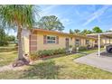 Inviting single-story home featuring a lush green lawn and a convenient carport at 4420 Tecumseh Trl # 38, Sarasota, FL 34233