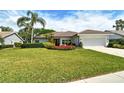 Charming one-story home featuring lush landscaping and a two-car garage at 4444 Highland Oaks Cir, Sarasota, FL 34235