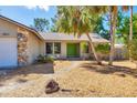 Close up of the home's entrance showing stone accents, a green front door, and xeriscaping at 480 58Th St, Sarasota, FL 34243