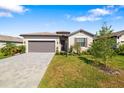 Attractive single-story home featuring a two-car garage, a paver driveway, and manicured landscaping at 5235 Coral Reef Way, Bradenton, FL 34211