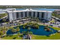 Birds eye view of the building featuring a serene blue pond, parking, and manicured grounds at 5855 Midnight Pass Rd # 204, Sarasota, FL 34242
