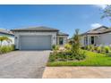 Charming single-story home with a gray-tiled roof, brick paved driveway, and well-manicured landscaping at 6260 Fish Eagle Ct, Nokomis, FL 34275