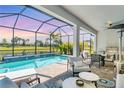 Screened-in lanai with a private pool and water feature overlooking a serene lake and beautiful sunset at 6260 Fish Eagle Ct, Nokomis, FL 34275