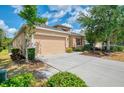 Well-maintained home with a spacious driveway, beautiful trees, and manicured landscaping at 6310 Golden Eye Gln, Lakewood Ranch, FL 34202