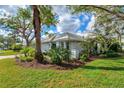 Lovely one-story home surrounded by lush landscaping and palm trees on a sunny day at 667 Crossfield Cir # 1, Venice, FL 34293