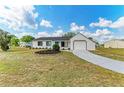 Cozy single-story residence with a green lawn, complemented by neatly arranged flower beds and an attached garage at 7002 Primm Pl, North Port, FL 34287