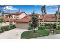 Charming home featuring a terracotta-tiled roof, lush landscaping, and a two-car garage at 7309 Regina Royale Blvd # 21, Sarasota, FL 34238