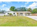 Beautiful home with a well-manicured lawn, palm trees, and a spacious driveway at 807 Harbor Ave, Ellenton, FL 34222