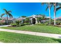 Inviting single-story home with a well-maintained lawn, palm trees, and meticulous landscaping at 8118 Waterview Blvd, Lakewood Ranch, FL 34202