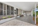 Spacious covered patio with neutral tones, white railings, and a decorative white brick base with green plants at 8517 Buckingham Pl, Palmetto, FL 34221
