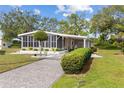 Charming home with screened in porch, driveway, and beautiful landscaping featuring well maintained bushes and grass at 8517 Buckingham Pl, Palmetto, FL 34221