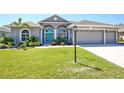 Charming home with arched windows, a bright blue door, and a well-manicured lawn at 8615 59Th E St, Parrish, FL 34219