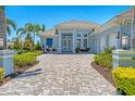 This beautiful home has a light blue exterior with large brick driveway and manicured landscaping at 16436 Daysailor Trl, Lakewood Ranch, FL 34202
