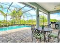 Open-air patio featuring a dining set, ceiling fan, brick pavers and views of the pool and lake at 11723 Cullen Park Ter, Bradenton, FL 34211