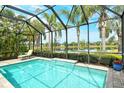 Relaxing screened-in pool with clear blue water, scenic lake views, and inviting lounge chair at 11723 Cullen Park Ter, Bradenton, FL 34211