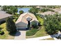 Beautiful home features a backyard, lawn, pond and lake views, and mature trees at 14404 Stirling Dr, Lakewood Ranch, FL 34202