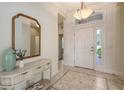 Spacious foyer with decorative console table, light fixture, and views into the home at 14404 Stirling Dr, Lakewood Ranch, FL 34202