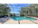 Relaxing screened-in pool and spa with a scenic lake view, surrounded by lush landscaping at 14404 Stirling Dr, Lakewood Ranch, FL 34202