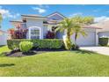Inviting single-story home featuring vibrant landscaping, mature trees, and a gray two-car garage at 16620 Fairbolt Way, Odessa, FL 33556