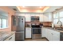 Well-lit kitchen featuring stainless steel appliances, white cabinetry, and countertop space at 1770 Lake Pl # 1770D, Venice, FL 34293