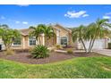 Beautiful home featuring a landscaped yard with palm trees and a well-maintained lawn at 1975 White Feather Ln, Nokomis, FL 34275