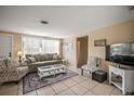Bright living room with tile floors, neutral walls, comfortable seating, and natural light at 2620 White Sands Dr, Sarasota, FL 34231