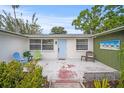 Cozy outdoor patio area with comfortable seating, a colorful door, and lovely landscaping at 2620 White Sands Dr, Sarasota, FL 34231