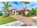 Beautiful Mediterranean-style home featuring a paver driveway, lush landscaping, and a three-car garage at 344 Maraviya Blvd, Nokomis, FL 34275