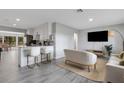 Bright, open-concept living area featuring a modern kitchen with a breakfast bar and views into a cozy, furnished seating area at 3857 Woodrow Ridge St, Sarasota, FL 34233