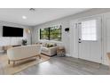Comfortable living room features large windows, modern furnishings, light gray walls, and a stylish jute rug at 3857 Woodrow Ridge St, Sarasota, FL 34233