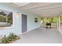 Spacious covered porch with gray concrete flooring and white railings, perfect for outdoor entertaining at 4111 Rockefeller Ave, Sarasota, FL 34231
