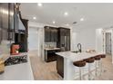 Modern kitchen features a large island with seating, stainless steel appliances, and elegant dark wood cabinetry at 4240 Pond Brook Ct, Bradenton, FL 34211