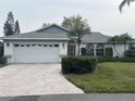 Single-story home with a brick driveway, two-car garage and well-maintained landscaping at 4538 Hamlets Grove Dr, Sarasota, FL 34235