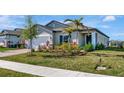 A lovely single-story home featuring a manicured lawn, complemented by vibrant landscaping and a brick driveway at 5307 Senza Trl, Palmetto, FL 34221