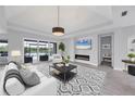 Elegant living room boasts a fireplace, tray ceiling, and sliding glass doors to the backyard at 659 Rosemary Cir, Bradenton, FL 34212