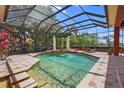 Screened-in pool area featuring a fountain, landscaping, and a seating area for relaxation at 7580 Preservation Dr, Sarasota, FL 34241