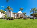 Scenic exterior view of a lovely condo featuring lush landscaping, mature palm trees and ample parking at 845 Benjamin Franklin Dr # 104, Sarasota, FL 34236