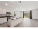Bright kitchen features stainless appliances, granite countertops, island, and tile flooring at 8600 Milestone Dr, Sarasota, FL 34238
