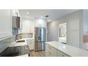 Modern kitchen features white cabinets, stainless steel appliances, tile backsplash, and breakfast bar at 117 7Th N St # 14, Bradenton Beach, FL 34217