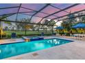 Relaxing pool area with comfortable lounge chairs, umbrella, and lush greenery at 15024 Castle Park Ter, Lakewood Ranch, FL 34202