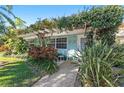 Charming cottage-style home with lush landscaping, pergola, and a welcoming front porch with seating at 1603 Gulf Dr N # 6, Bradenton Beach, FL 34217