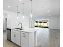 Bright kitchen with quartz countertops, stainless steel appliances, and an open layout to the dining area at 16097 Old Fox Trl, Port Charlotte, FL 33953