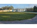 Manicured front yard with a charming single-story home featuring fresh paint and landscaping at 1750 Gold Ave, Sarasota, FL 34235