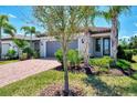Attractive home featuring a red brick driveway, gray garage door, and well-manicured landscaping with lush bushes at 17714 Northwood Pl, Bradenton, FL 34202