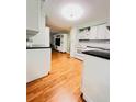 Bright kitchen view with a living space, white cabinets, and hardwood floors at 1829 Cypress Point Ln, Sarasota, FL 34234