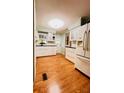Bright kitchen with white cabinets, a white refrigerator, and hardwood floors at 1829 Cypress Point Ln, Sarasota, FL 34234