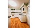 Bright kitchen with white cabinets, a white oven and hardwood floors at 1829 Cypress Point Ln, Sarasota, FL 34234
