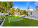 Expansive backyard showcasing a putting green and lounge chairs, perfect for entertaining and relaxation at 414 79Th St, Holmes Beach, FL 34217