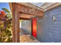 View of the front door from the exterior with a stone walkway and stylish overhead beam at 448 58Th St, Sarasota, FL 34243