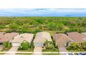 Aerial view of home showcasing landscaping, a brick driveway, and a view of the surrounding greenery at 5416 Hope Sound Cir, Sarasota, FL 34238